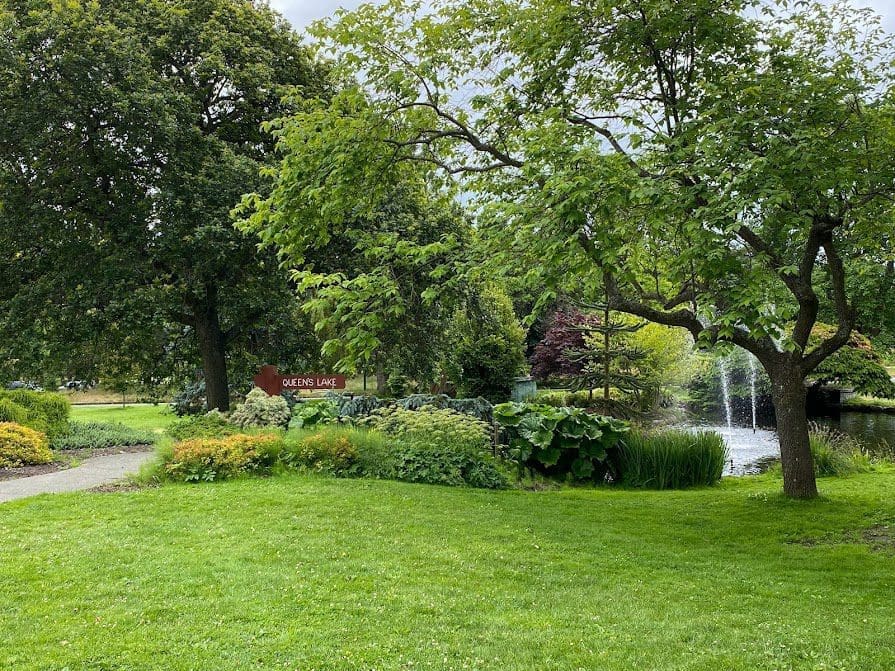 Queens Lake sign and fountain behind